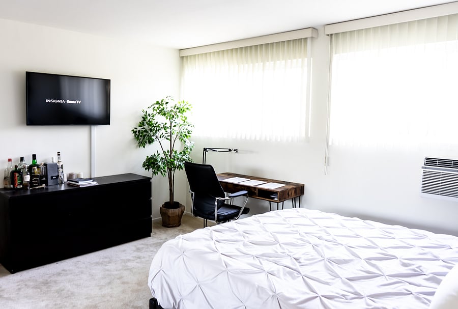 Bedroom 1 with work comfortable queen bed, work desk, personal AC, drawers for storage, a 4k smart Roku TV, and a private ensuite bathroom.