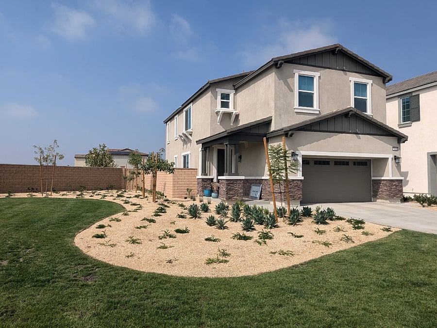 House exterior with grass area with benches.