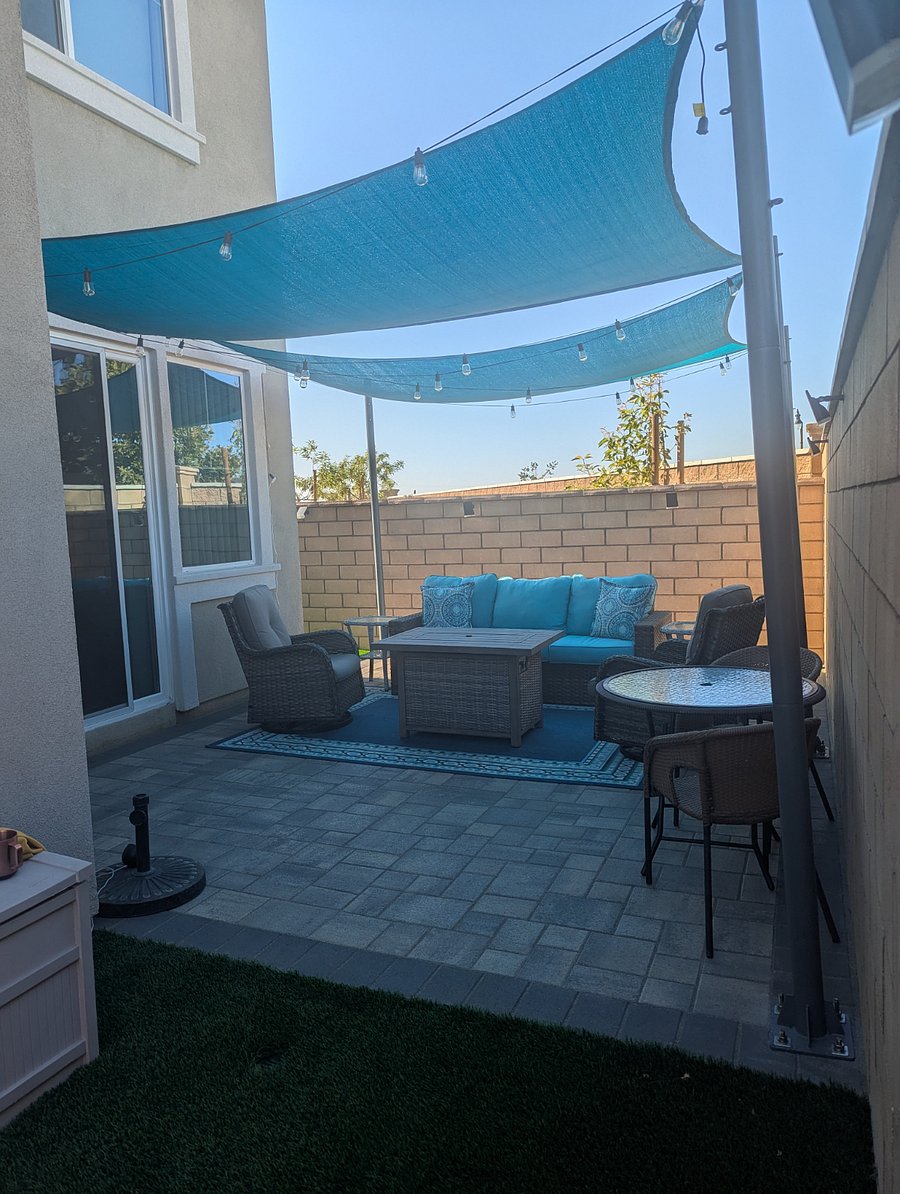 Furnished covered patio with rocker chairs and fire pit table.