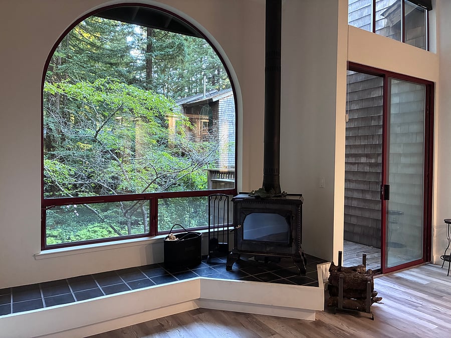 Picture window on main level, wood burning stove w/fireplace tools, small wood rack, and carry bag