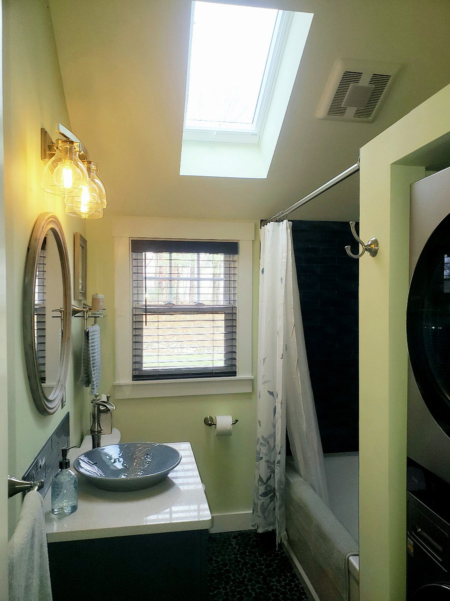 Bathroom has deep soaking tub and stacked washer and dryer