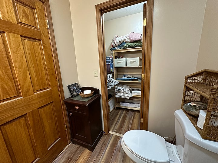 Sm iron and ironing board, cleaning supplies, towels sheets and blankets in closet.