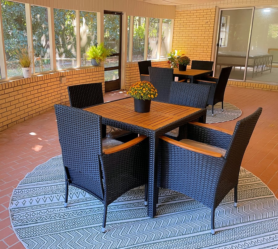 Screened outdoor space with seating for eight. Ceiling fan overhead for air circulation.