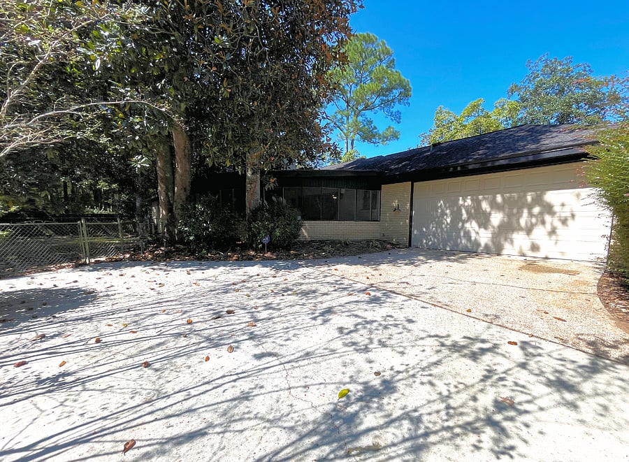 Rear view of home with oversized side parking and fenced yard for pets.