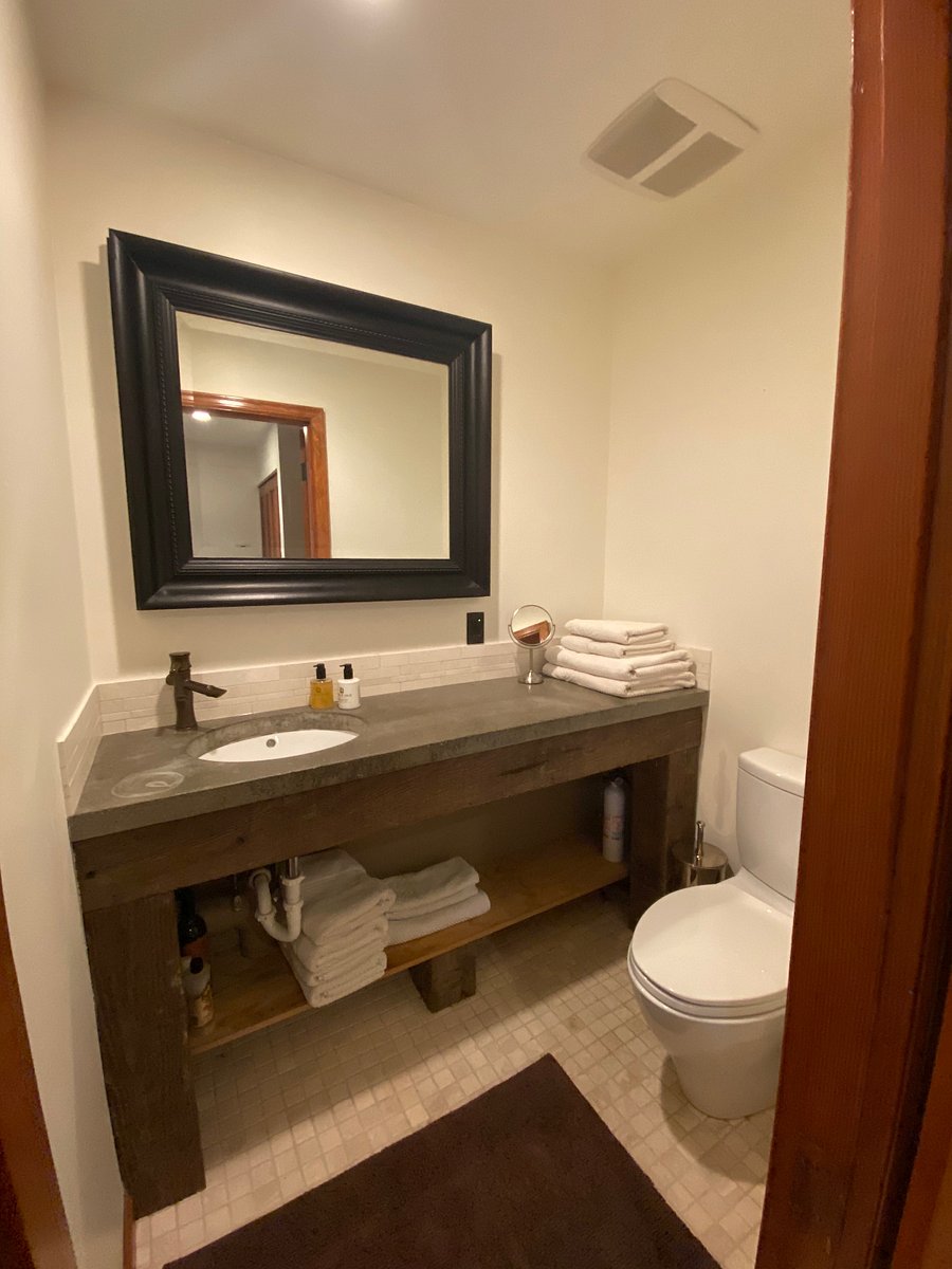 Custom private powder room. Toto toilet, Douglas Fir beam and concrete countertop with a honed marble surround.