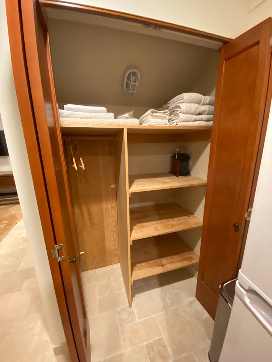 Closet with hanging space l/wooden hangers, shelves, linens, towels.