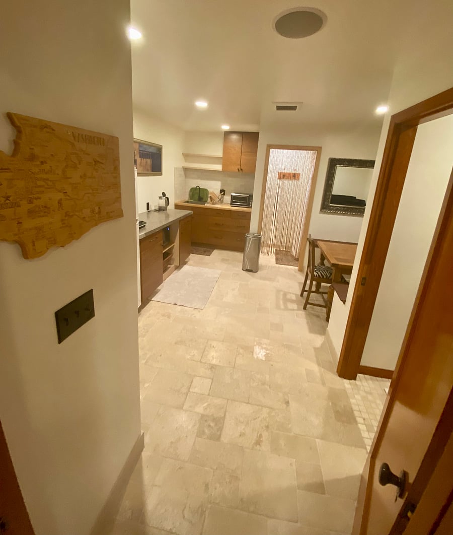 Pocket door separates kitchenette/dining/powder room/walk-in shower from bedroom. Travertine stone floors are heated in the winter and cool in the summer.
