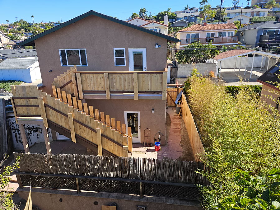 Yard area, stairs, balcony and entry door.