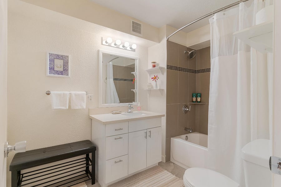 Full bathroom with very large newly tiled shower. The curved shower rod creates plenty of space inside the shower.