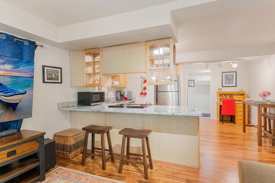 View of the kitchen/dining area from the living room. The stools from the dining table can also be used at the counter.