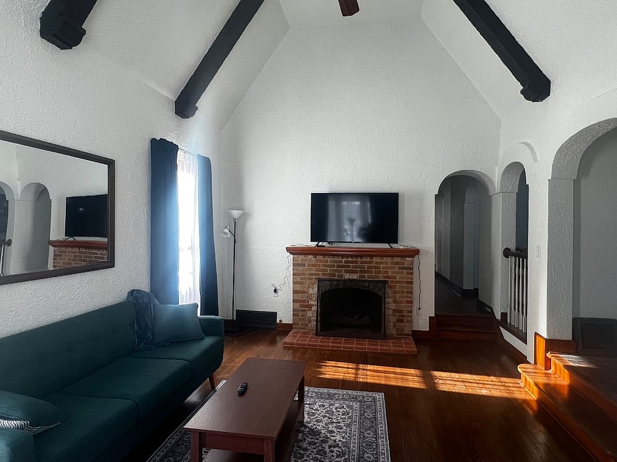 Sunken living room has gas fireplace and large screen smart TV
