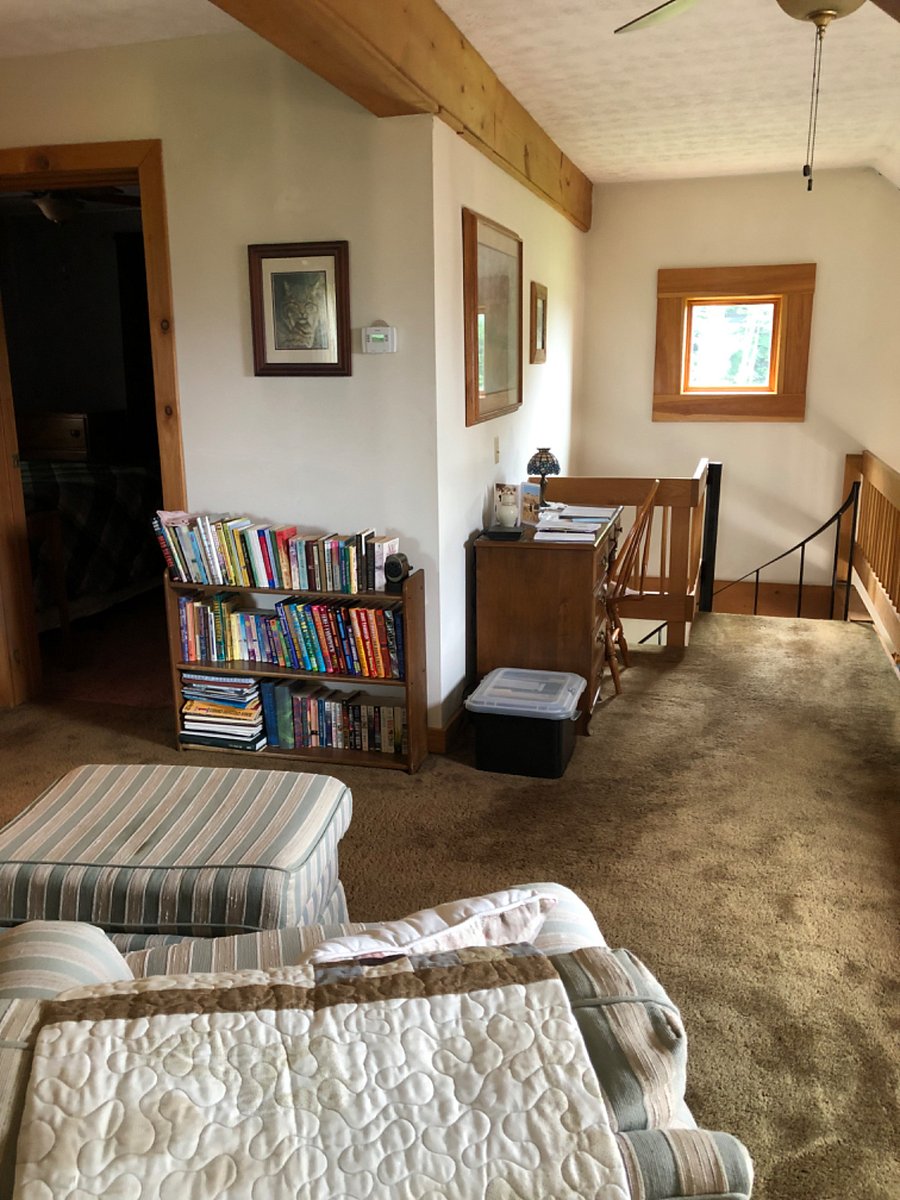 Upstairs landing with sitting area. Books and 2 comfy chairs with ottoman and lamp. So cozy!
