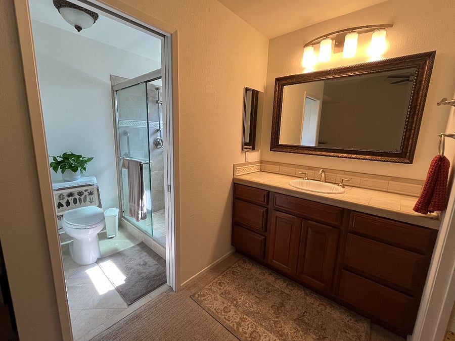 Private en-suite bathroom includes large vanity with lots of storage, medicine cabinet and sink.