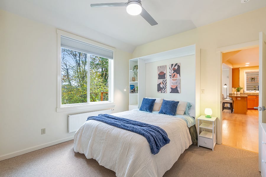 This is bedroom 2 in the downstairs. It includes a queen-sized bed with a high-quality mattress, blackening blinds, a large dresser, smart TV, and a closet across an entire wall.