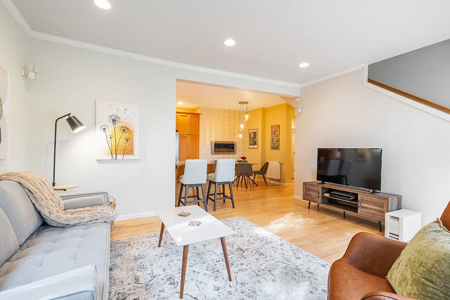 Living room is part of an open layout great room, tons of natural light, a 60" smart TV, Bose sound system, and access to a large deck.