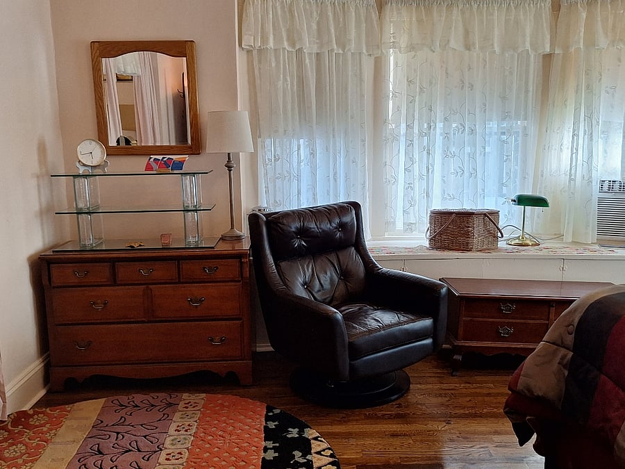 Bedroom lounge area with dresser and mirror  