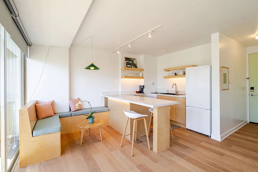 Open-plan living and kitchen with birch finishes, natural light, and lanai access.