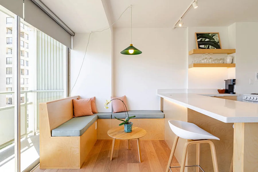 Custom banquette with hidden storage, pendant light, and bar seating  open to the kitchen and lanai.