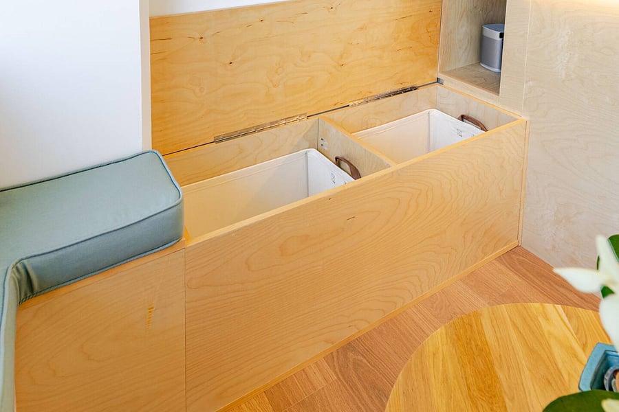 Custom birch bench seat opens to reveal generous hidden storage, smart use of every inch.