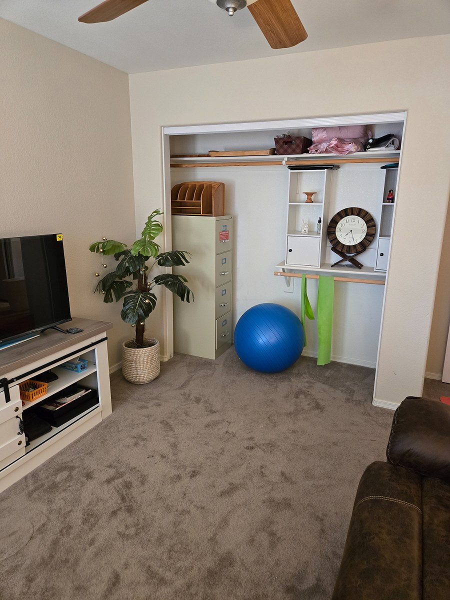 Office area with light exercise equipment abd file cabinet, TV