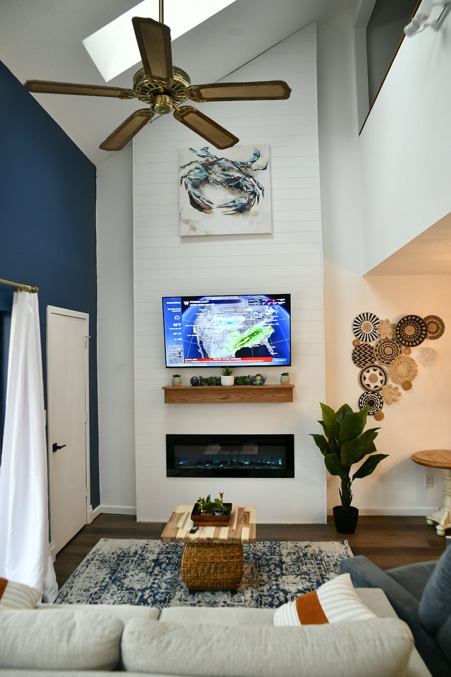 Spacious Living room with 55 inch Smart TV and Electric fireplace. Features a 17 ft fireplace wall.