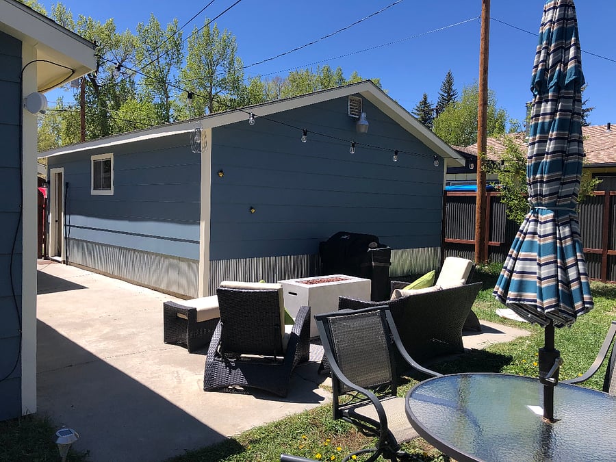 Private back yard with dining table, lounge area and gas grill