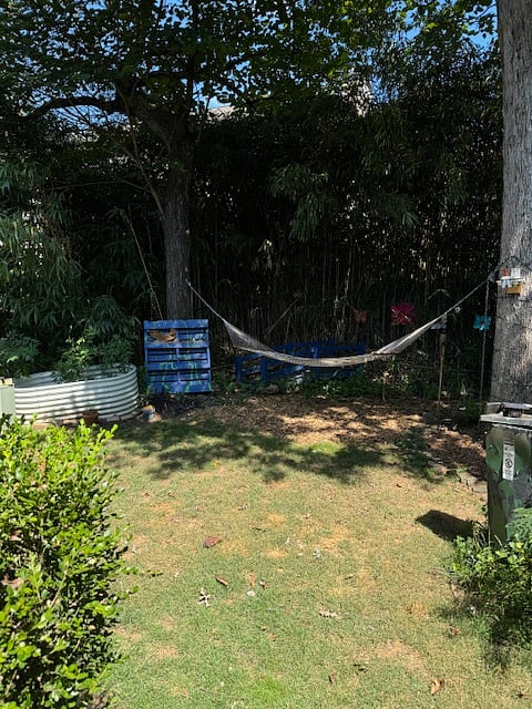 Backyard has a garden, a hammock, and a Projector screen set up for movie nights