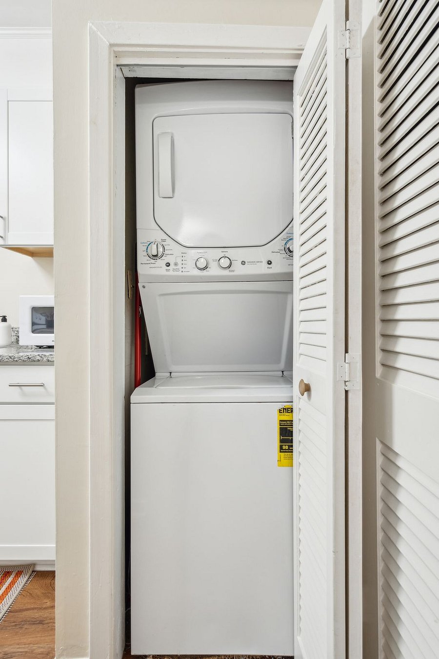 Tucked in a closet within the kitchen is the stacked washer and dryer unit.