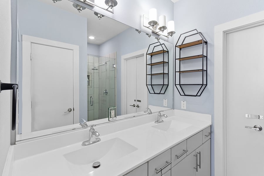 No morning rush here! Enjoy the convenience of a dual-sink vanity, expansive mirror, and modern geometric storage shelves. Complete with a beautiful walk-in shower and bidet attachment.