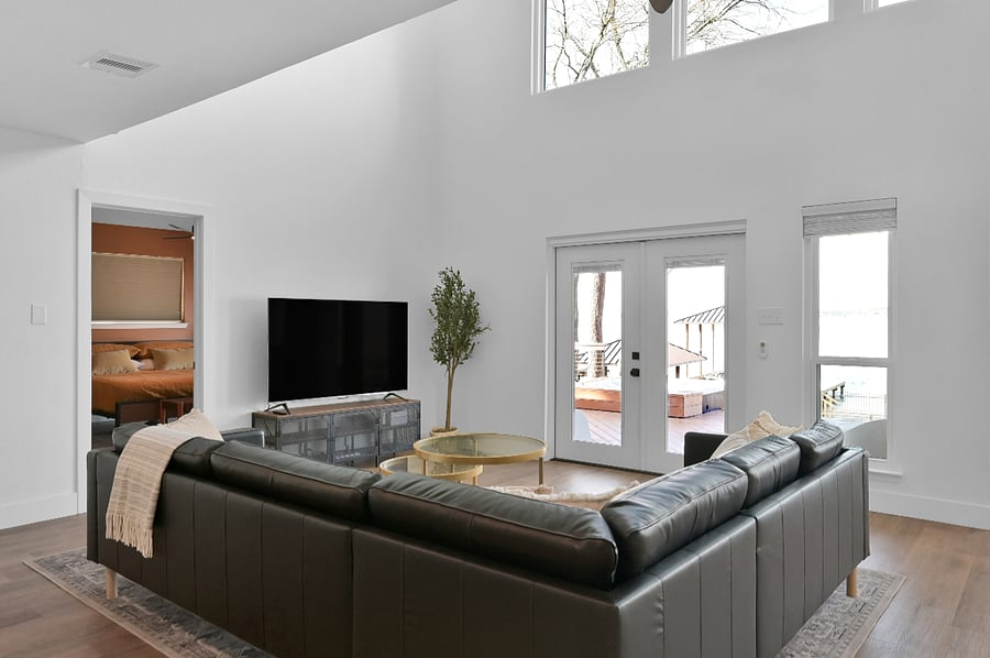 Here you see the 65 inch tv and views of the lake.
The primary bedroom is seen thru the doorway.