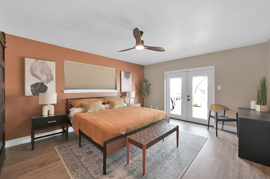The primary bedroom has a king bed and a desk. The french doors open to the oversized deck with hot tub.