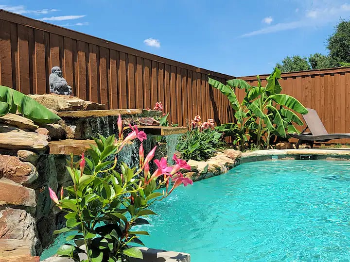 Find your happy place lying by the pool, listening to waterfall with smiling Buddha.