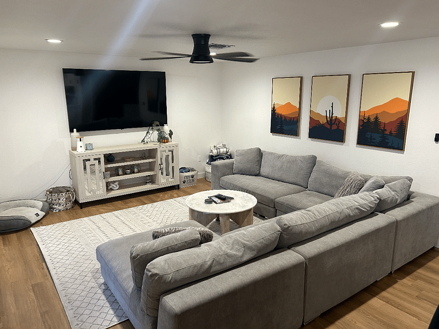 Living room (off of kitchen) with large 80" smart TV and large sectional