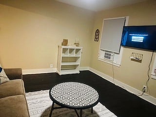 Smart TV and window AC unit in living room.
