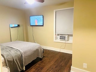 Smart TV and window AC unit in bed room.