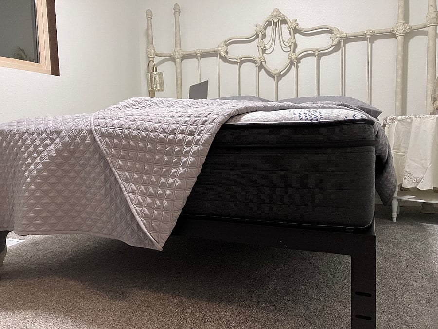 Old fashioned room, bed frame, and plush mattress. 