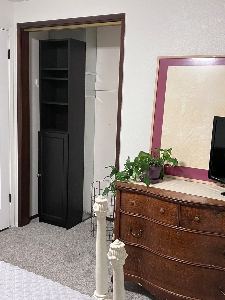 Old fashioned bedroom, closet with cabinet and laundry basket.