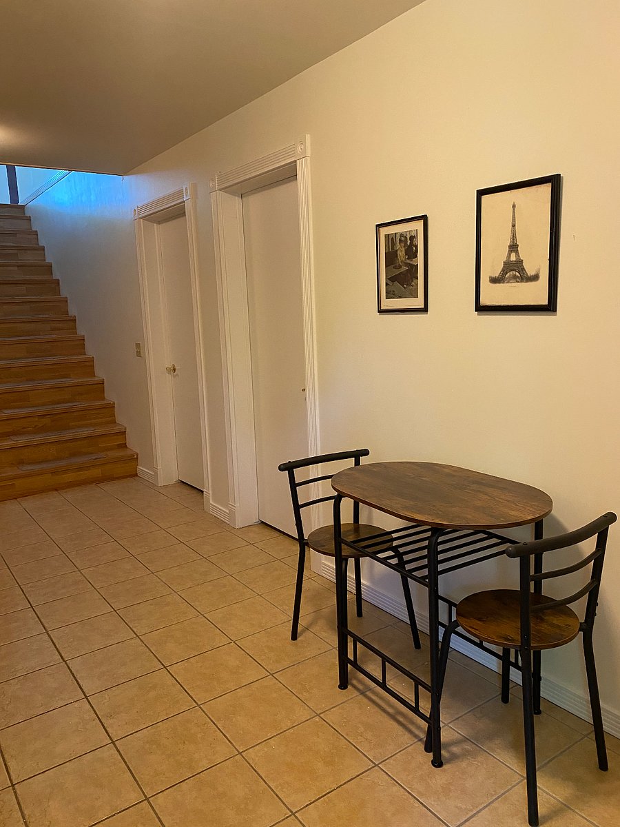 Table and  chairs in hallway, stairs leading to owners area. 