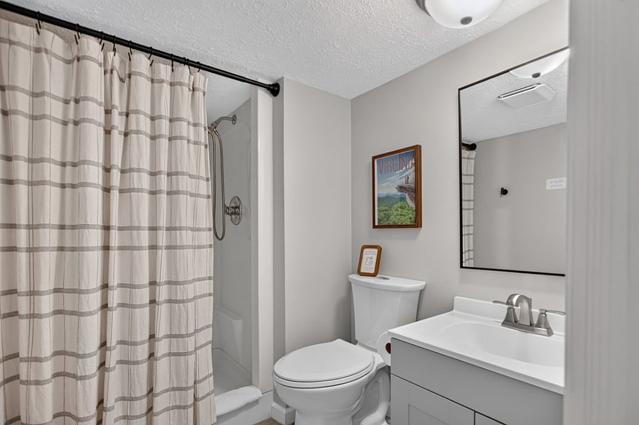 Basement studio bathroom with walk-in shower. Not recommended for individuals over 6 feet due to lower ceilings. 