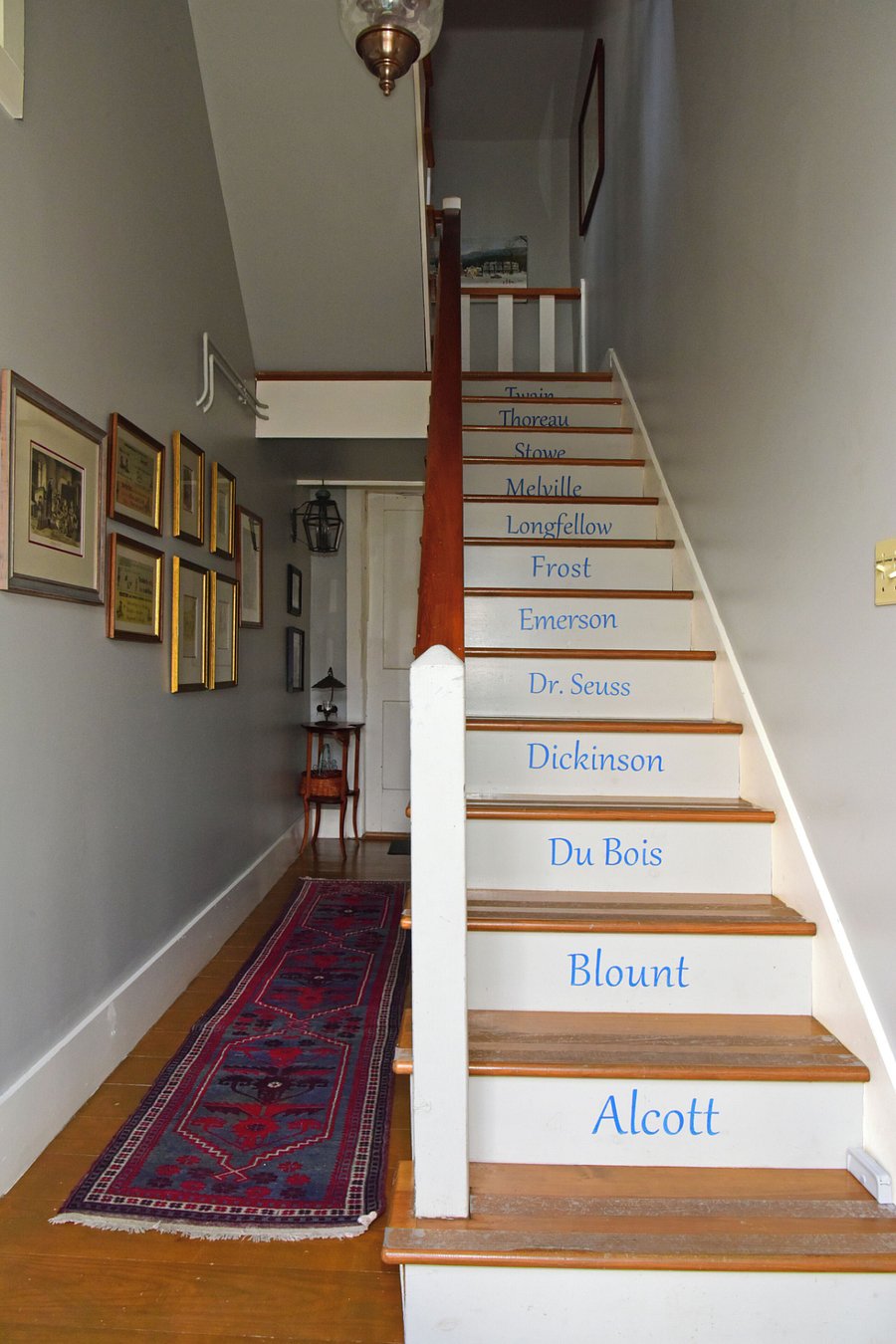 Stair way to loft with New England author stenciled artwork.