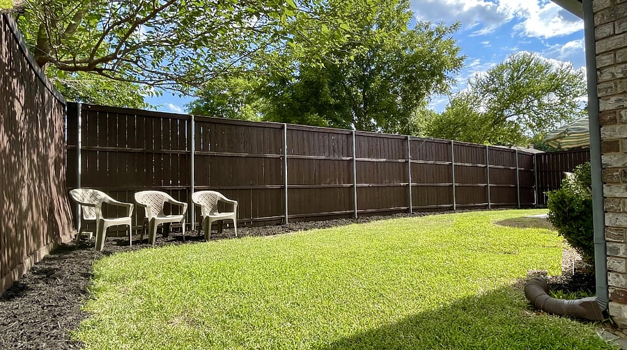 The backyard is fully fenced with an 8 ft privacy fence, patio with an outdoor dining set and grill.