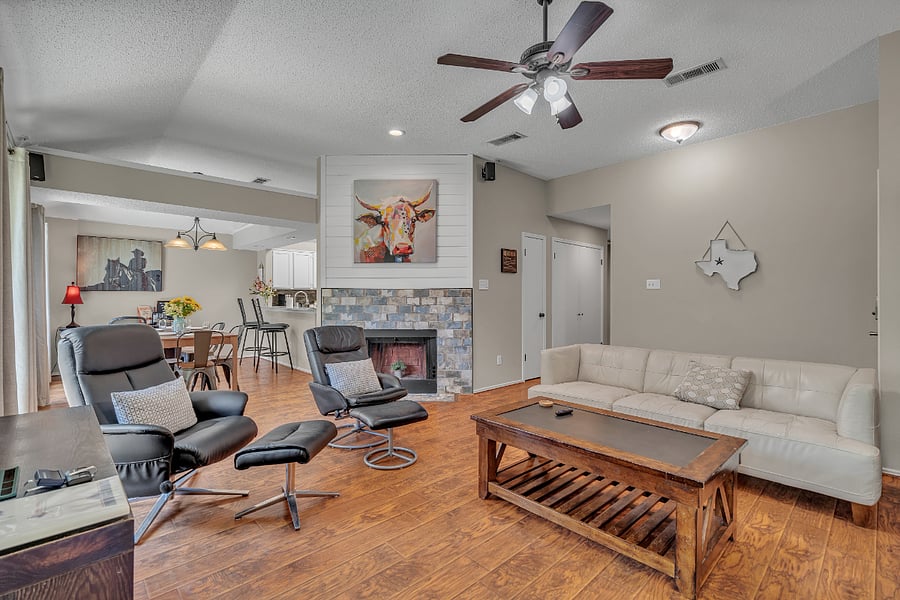 The living room features two leather sofas and two reclining chairs, with a wood-burning fireplace.