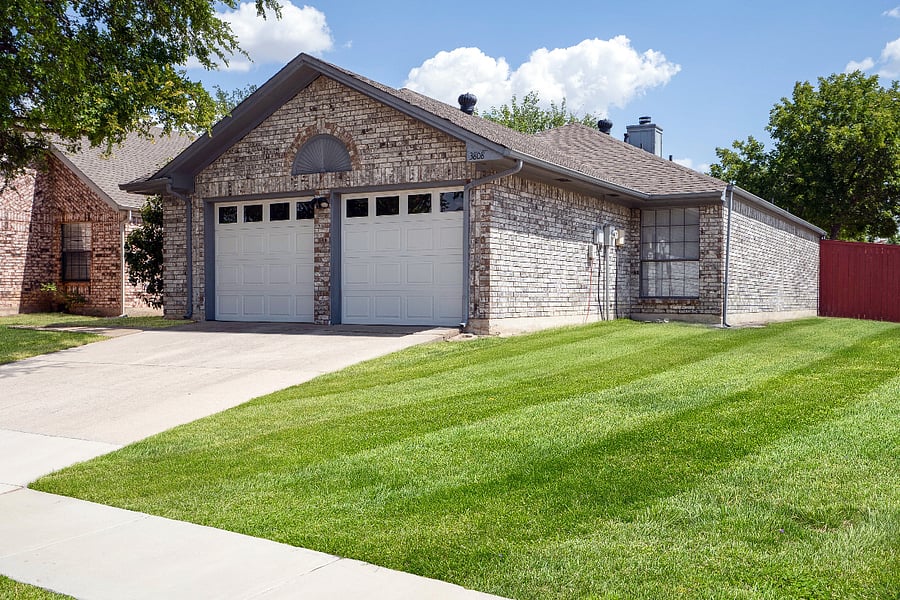 Front of the home with a 2-car garage, front driveway, and a large, corner lot. A nice private area. A greenbelt is behind the back fence, and the neighborhood has new sidewalks throughout.