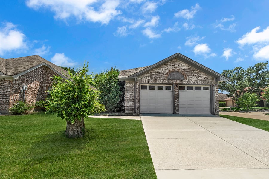 Front of the home with a 2-car garage, front driveway, and a large, corner lot. A nice private area. A greenbelt is behind the back fence, and the neighborhood has new sidewalks throughout.