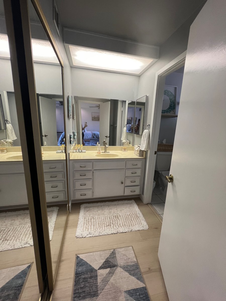 Bathroom vanity has full closet with wall to wall full length mirrors.