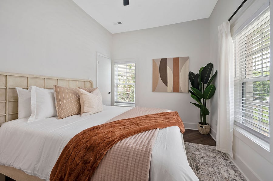 Unwind in the third bedroom, featuring a bright ambiance with a comfortable queen bed and a spacious walk-in closet for your convenience.