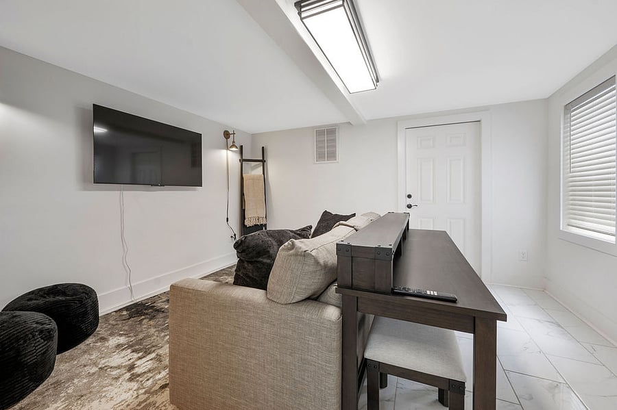 Flex-Office-Lounge is a versatile space that includes a desk and stools for work or relaxation while enjoying the Smart TV. The comfy pull-out couch is perfect for lounging, with a full bathroom nearby for added convenience.