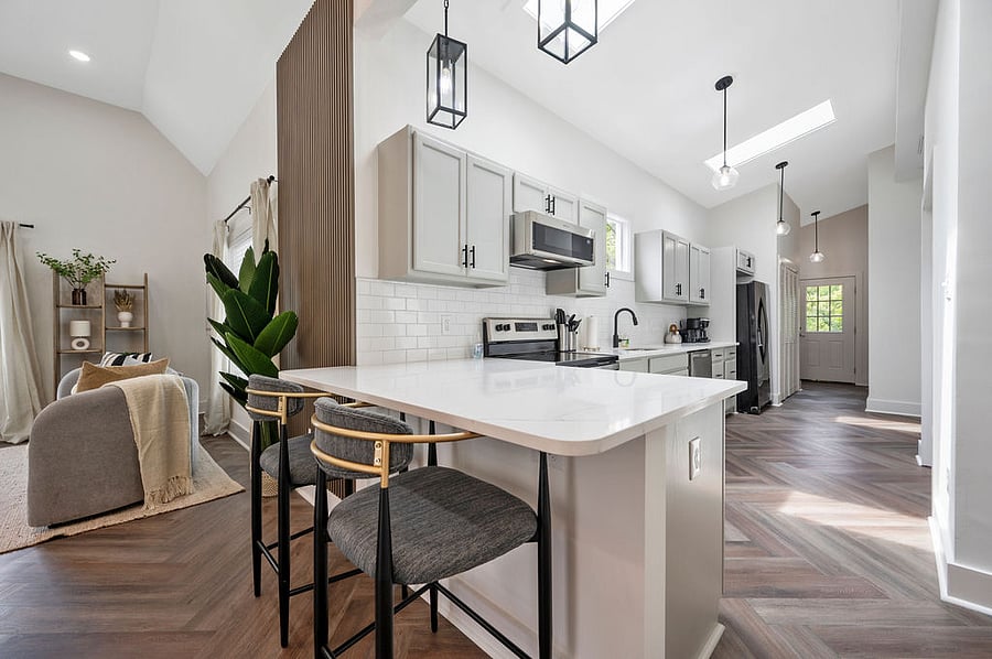 .A spacious island with comfortable counter chairs provides extra seating, ideal for quick bites, casual dining, or socializing with guests.