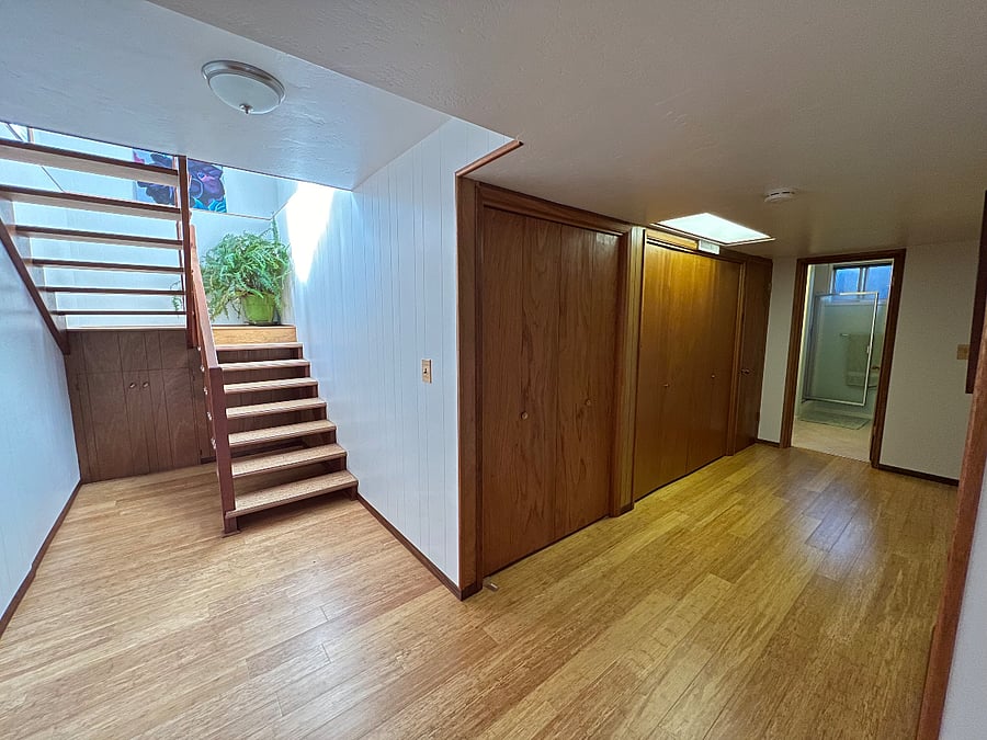 Hallway with large storage closets, private bath on right taken from private bedroom / living room doorway