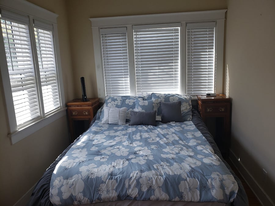 Bedroom with plenty of windows with shades and sleep number queen bed